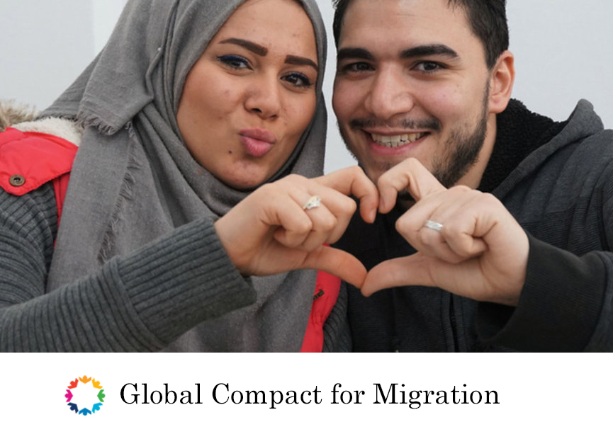 Compact for migration - man and woman make a heart symbol with their hands