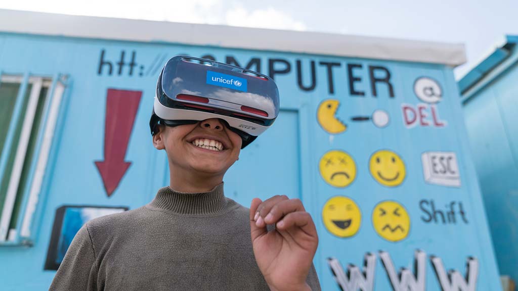 Mansoor, 12, watches the virtual reality documentary ‘Clouds over Sidra’ with a big grin, outside a UNICEF-supported Makani centre in the Za’atari camp for Syrian refugees. Photo: UNICEF/Herwig