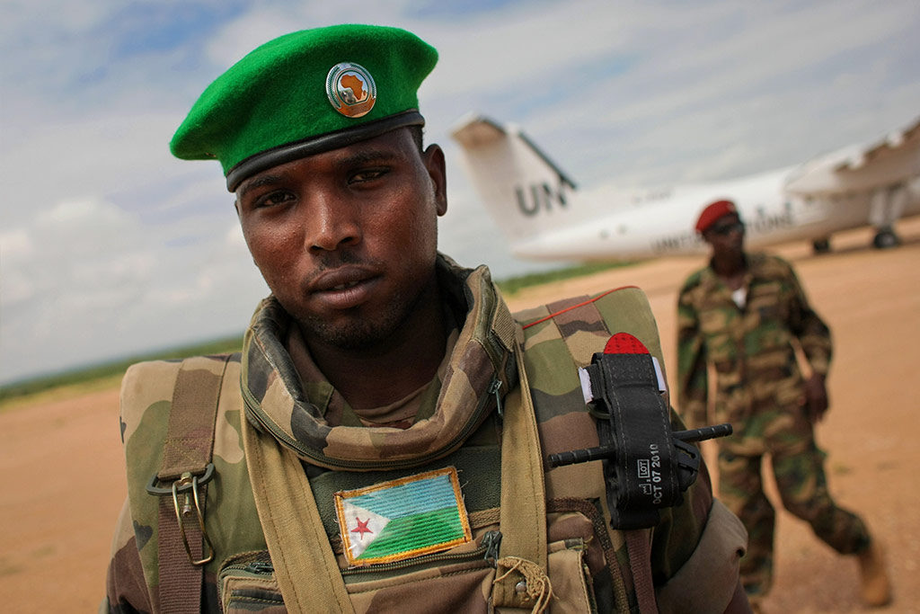 Un soldado del Contingente de Djibouti que sirve en la Misión de la Unión Africana en Somalia (AMISOM) está de guardia cuando un avión de las Naciones Unidas se prepara para el despegue del aeropuerto Belet Weyne. Foto AU/Stuart Price