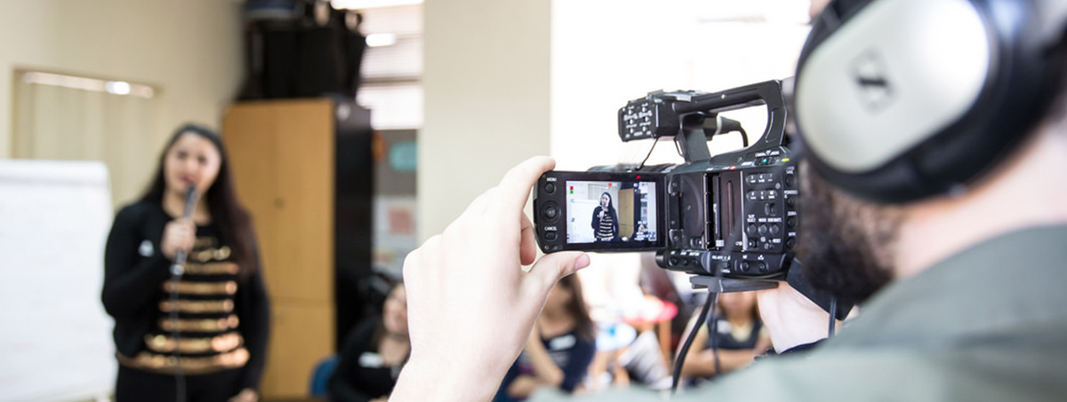 Participantes aprendiendo cómo filmar, hablar a cámara y usar un micrófono de mano.