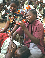 Распространение информации о ВИЧ/СПИД по средствам театрализованных представлений в Танзании. На данном изображении мать оплакивает свою дочь, которая только что умерла от СПИДа.  Фото ЮНИСЕФ.