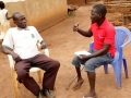 Home Health Promoter Eliaba Anthony Amba (right) speaks with Bennet Khamis.