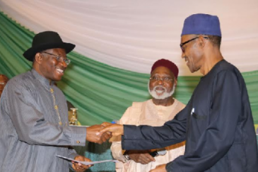 Former Nigerian President Goodluck Jonathan (left) and President-elect Muhammadu Buhari shake hands. In the middle is former head of state, Gen (Rtd) Abdulsalam Abubakar.