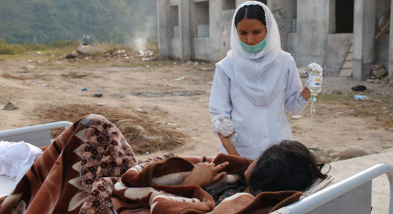 Natural disasters increase the health risks to those affected. In this picture, a nurse treats a patient at a temporary field hospital set up outside the Abbas Institute of Medical Sciences in Muzaffarabad, Pakistan.