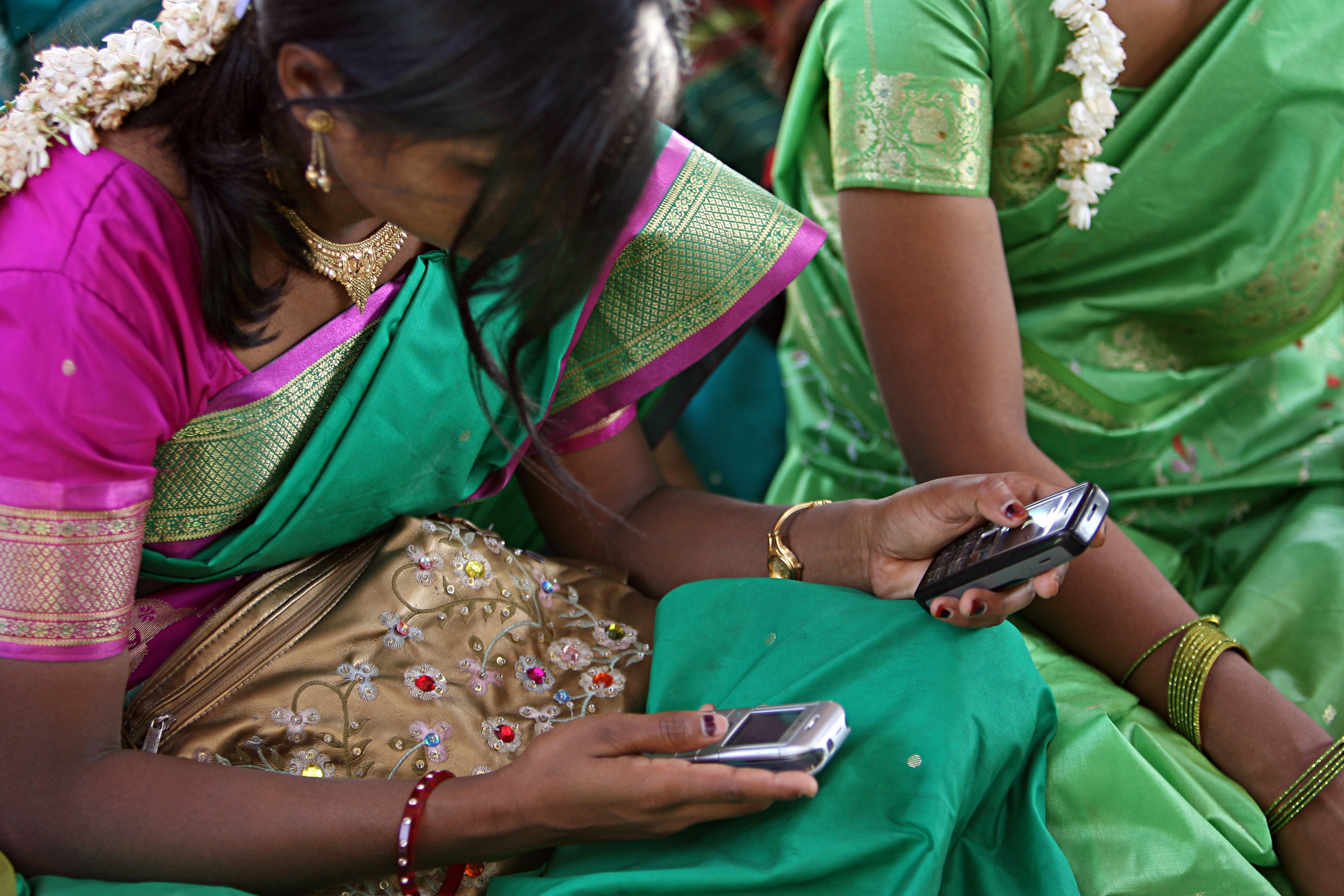 Unas jóvenes miran su móvil durante una reunión.