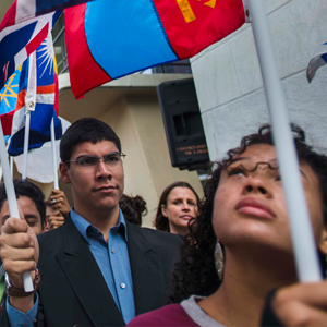 Unos estudiantes portan las banderas de los Estados Miembros durante la ceremonia anual de la Campana de la paz, en la Sede de las Naciones Unidas, en Nueva York, en 2015.