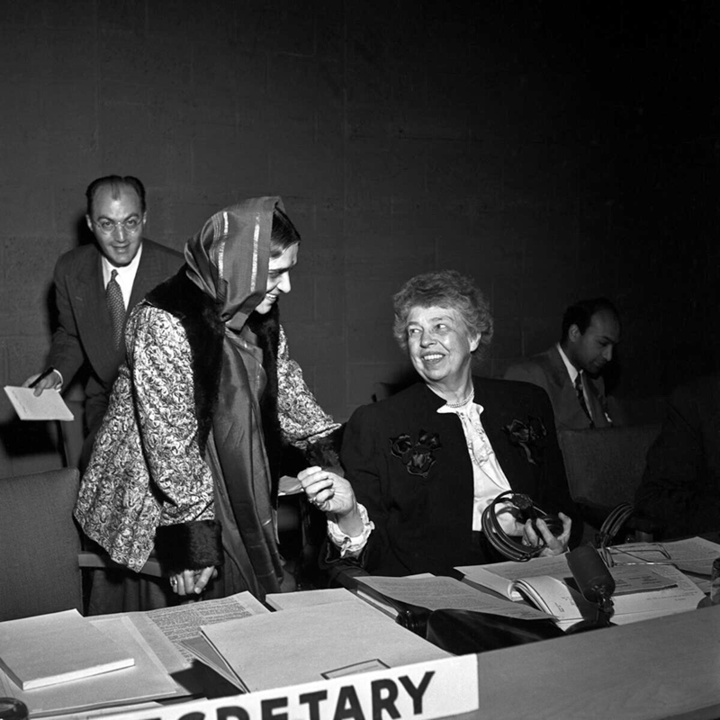 La Sra. Eleanor Roosevelt, sentada a la derecha hablando con la Sra. Hansa Mehta, que está a su lado.
