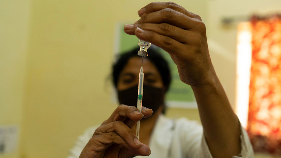 health worker holding vaccine syringe