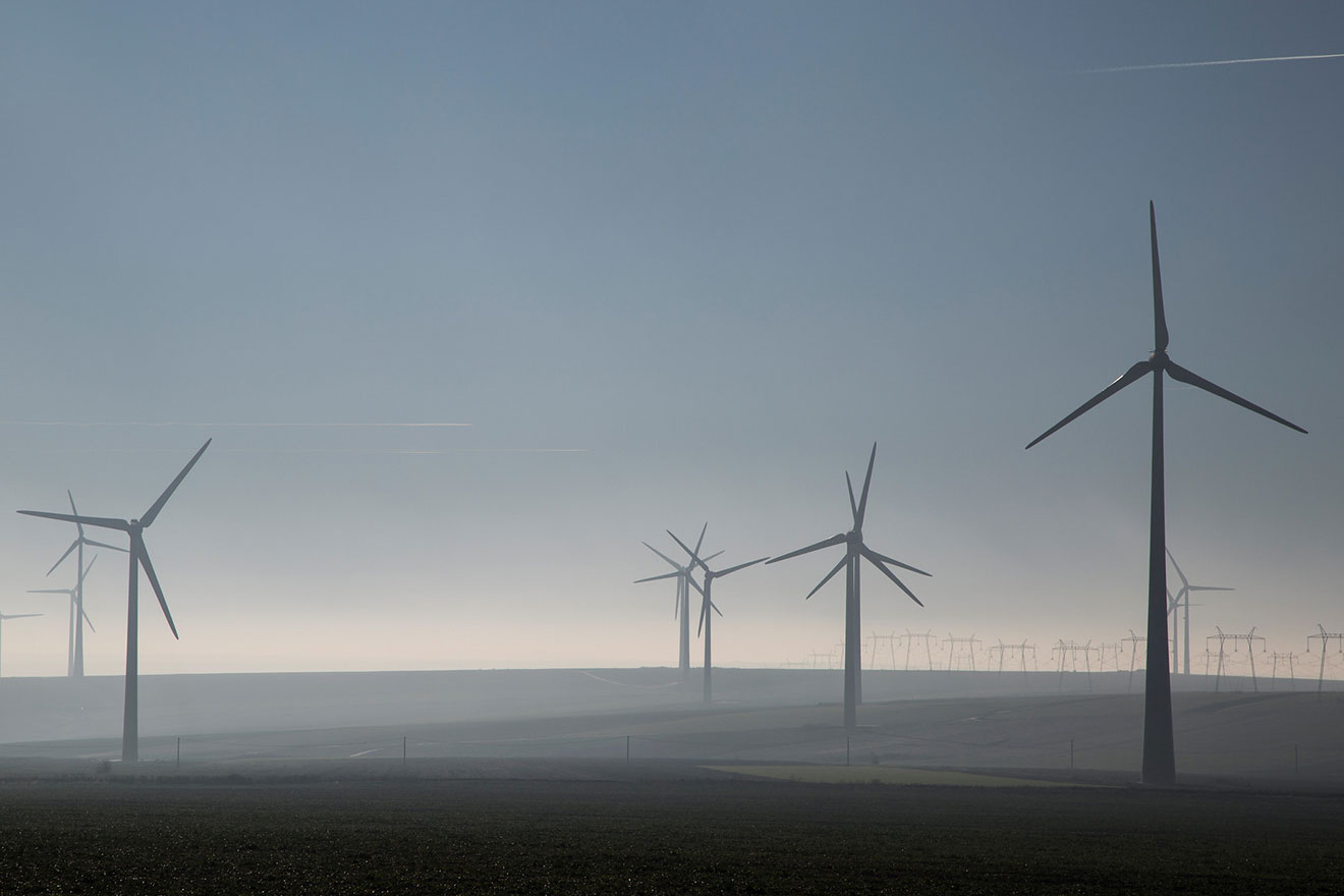 A wind farm with turbines among mist