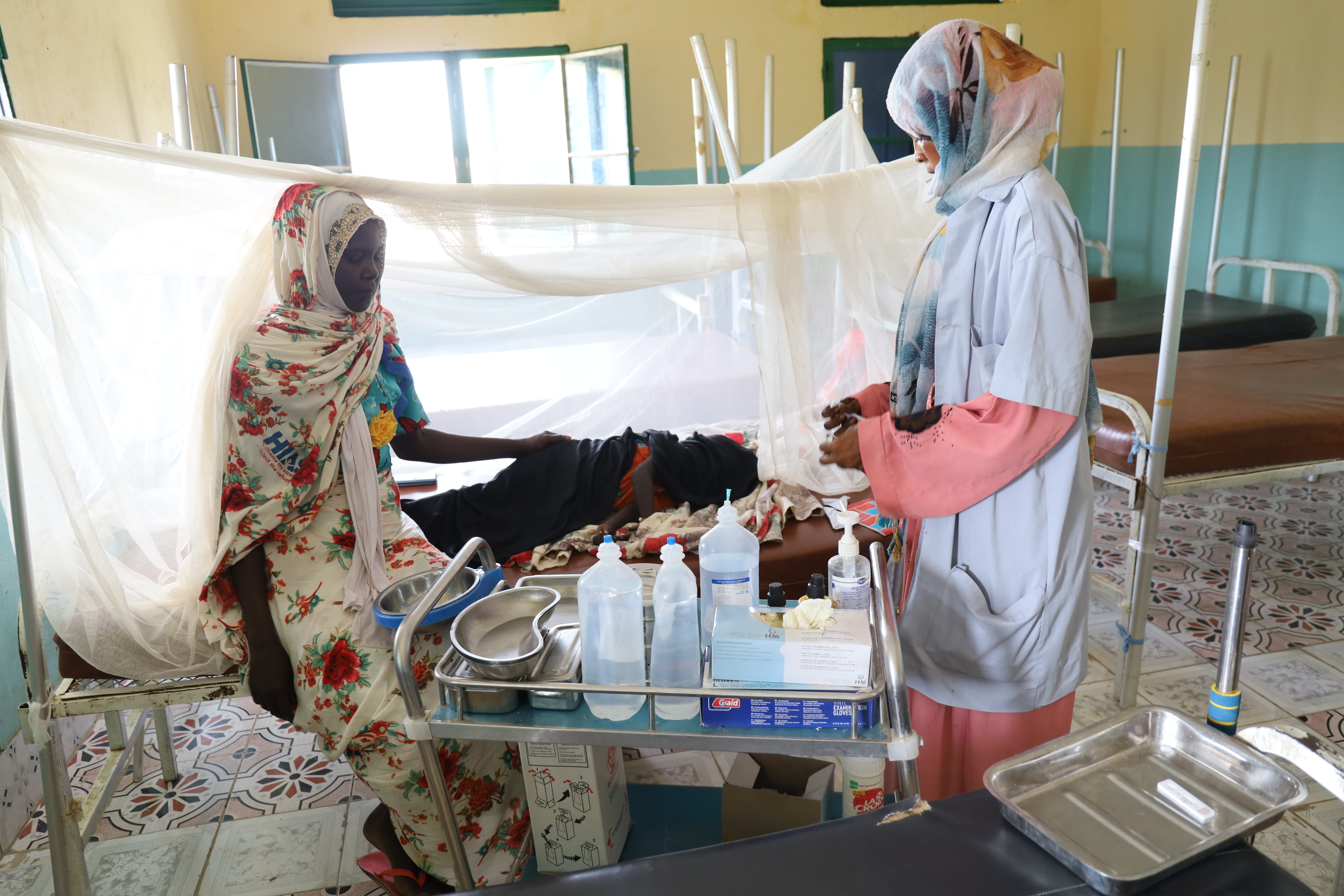 Deux femmes aux chevets d'un enfant dans un hôpital au Soudan