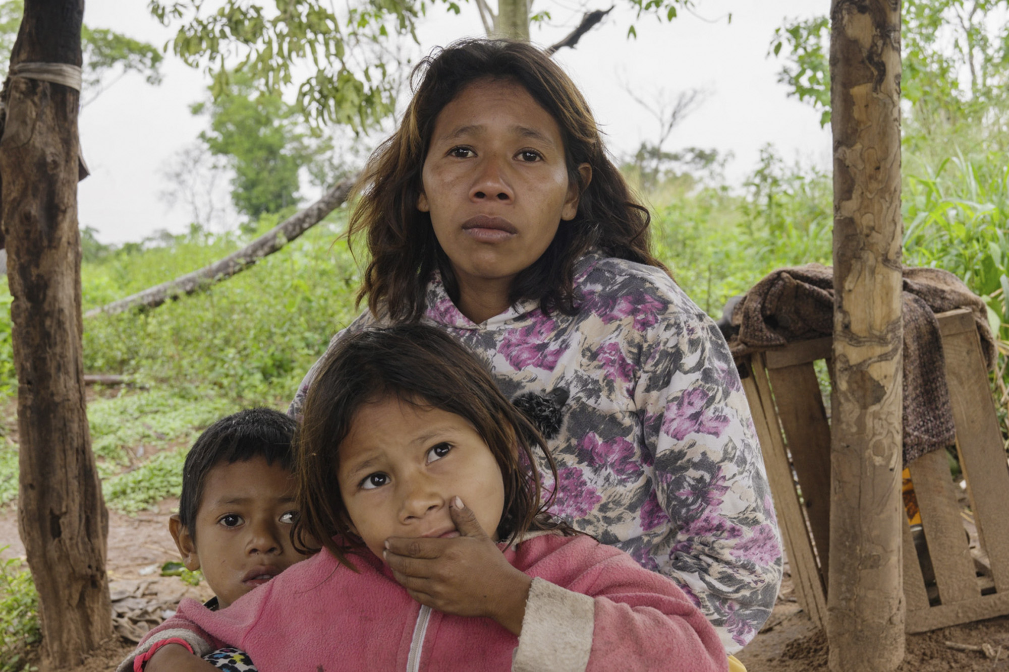 A woman and her two children in a Paraguayan community affected by deforestation.