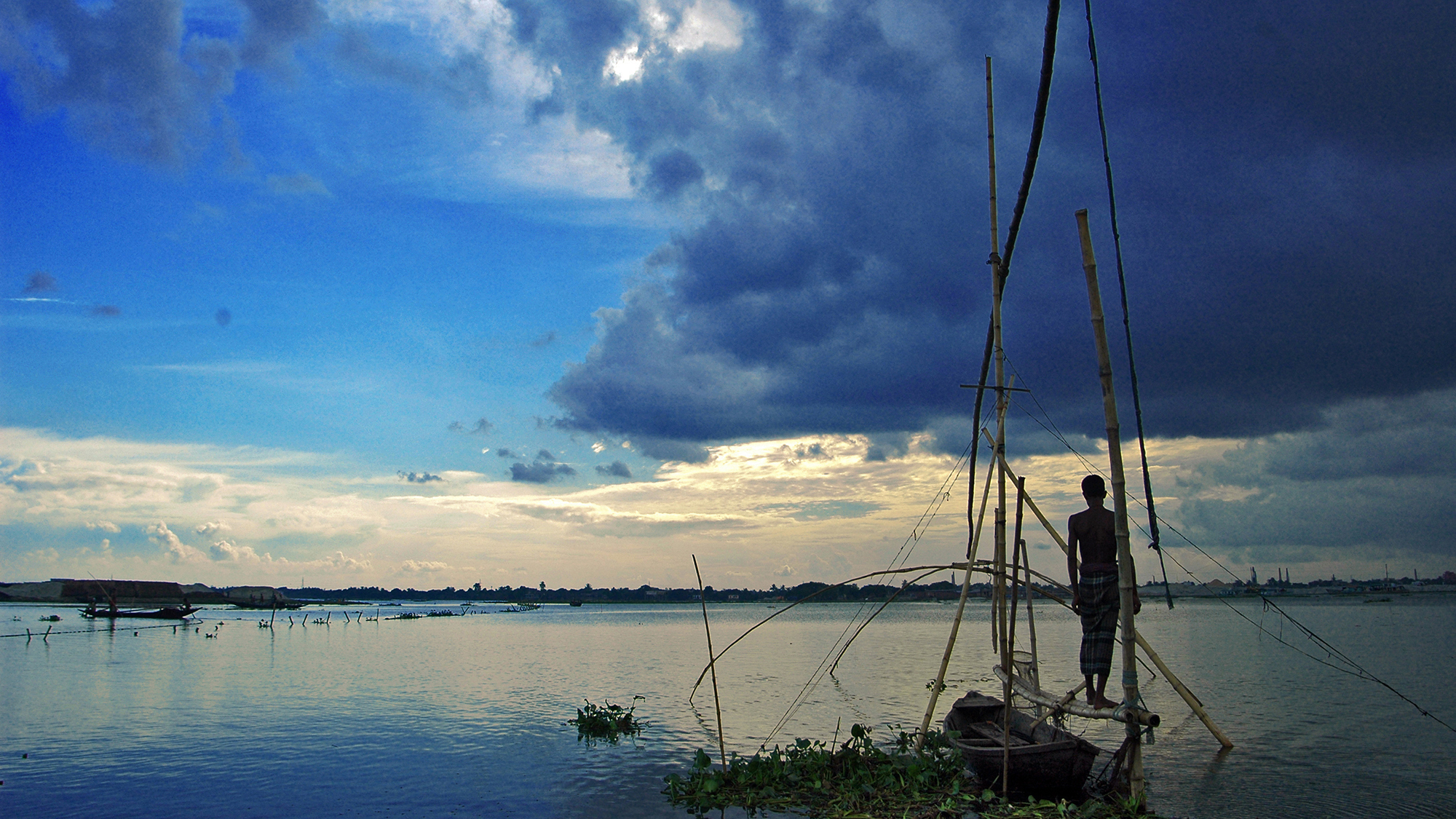  Un pêcheur debout regarde l'horizon.