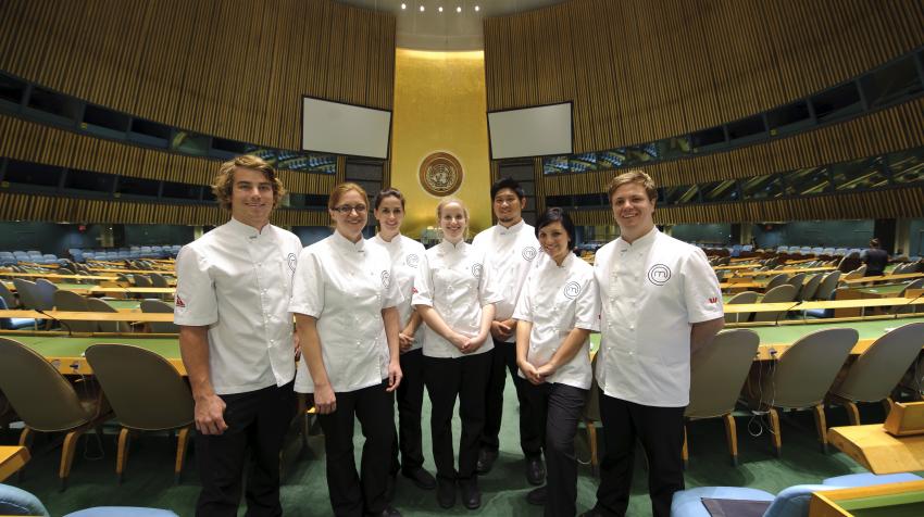 Master chef crew, all dressed in white chef uniforms, are standing in the General Assembly Hall. 