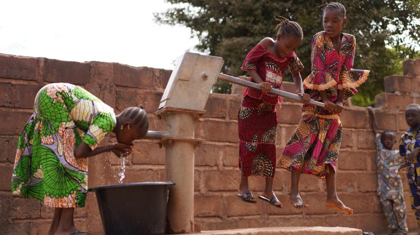 Young Girls Pumping Water At A Public Borehole in West Africa. By Riccardo Niels Mayer/Adobe Stock
