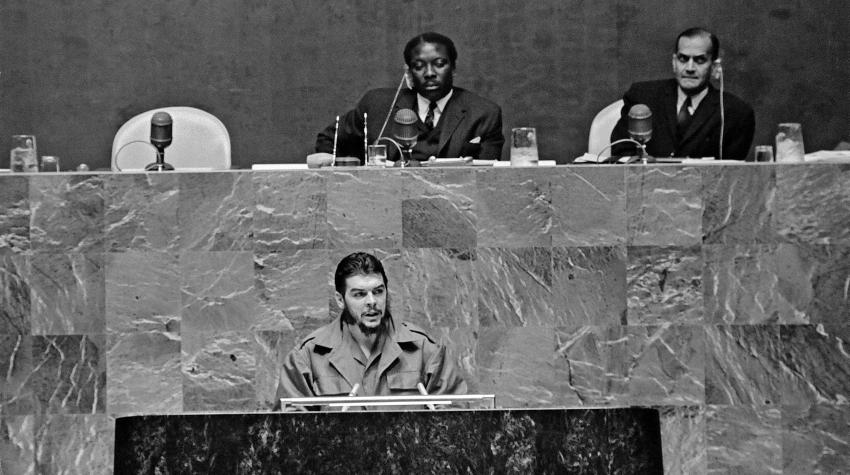 Black and white photo of actor speaking behind podium in the General Assembly. 